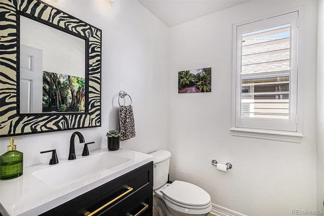 a bathroom with a toilet a sink and mirror