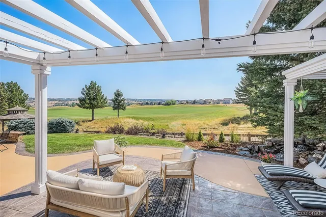 a view of a patio with lawn chairs floor to ceiling window and yard