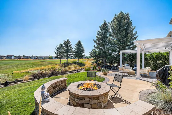 a view of a swimming pool and lounge chairs in back yard of the house