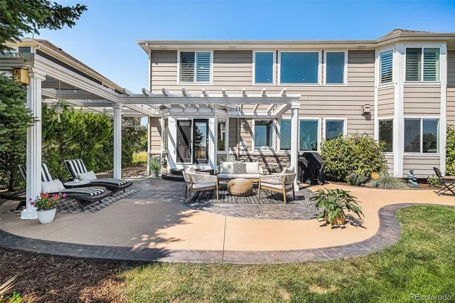 a view of a house with backyard and sitting area