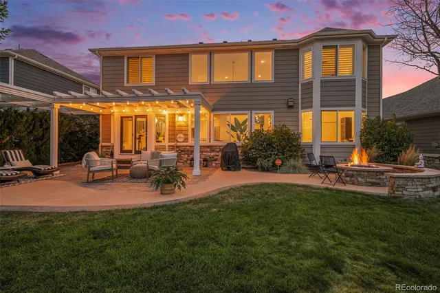 a view of a house with backyard and sitting area