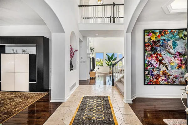 a hallway with wooden floor and a rug
