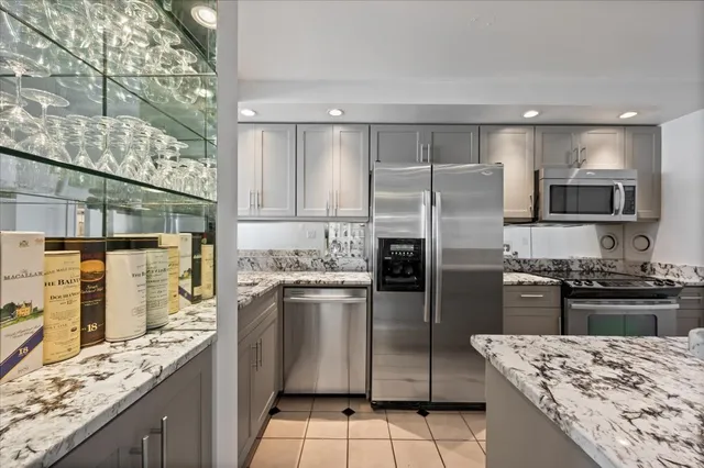a kitchen with kitchen island granite countertop a sink stove and refrigerator