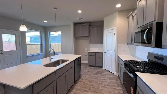 a room with kitchen island a sink and a refrigerator