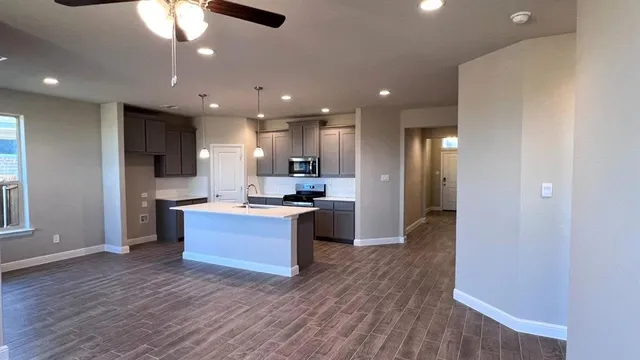 a kitchen with a sink chandelier and wooden floor