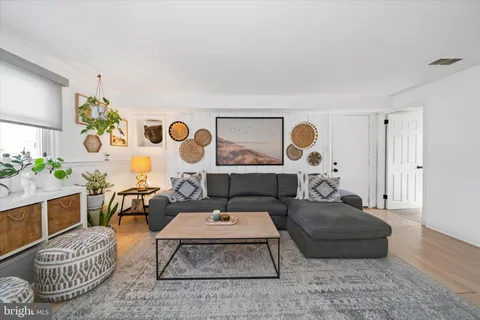 a living room with furniture rug and wall painting