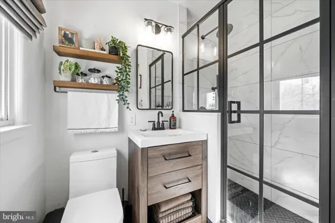 a bathroom with a toilet sink and mirror