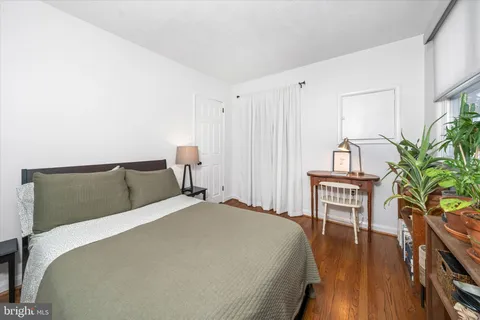 a bed sitting in a bedroom next to a window with wooden floor