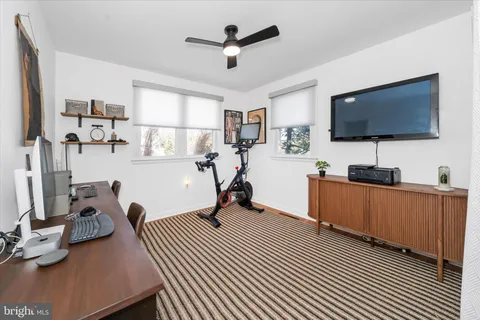 a view of a livingroom with workspace and a flat screen tv