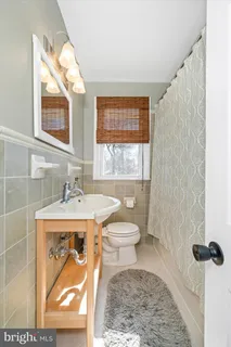a bathroom with a toilet a sink and mirror