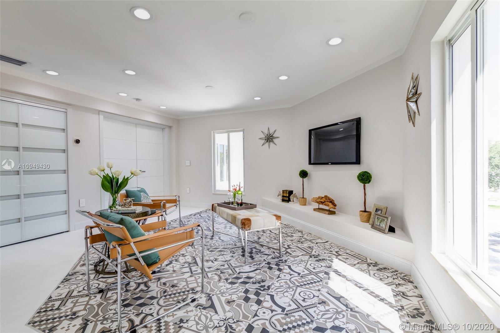 6030 Alton Road Miami Beach, FL 33140 - Photo 28 of 51 a living room with furniture and a flat screen tv