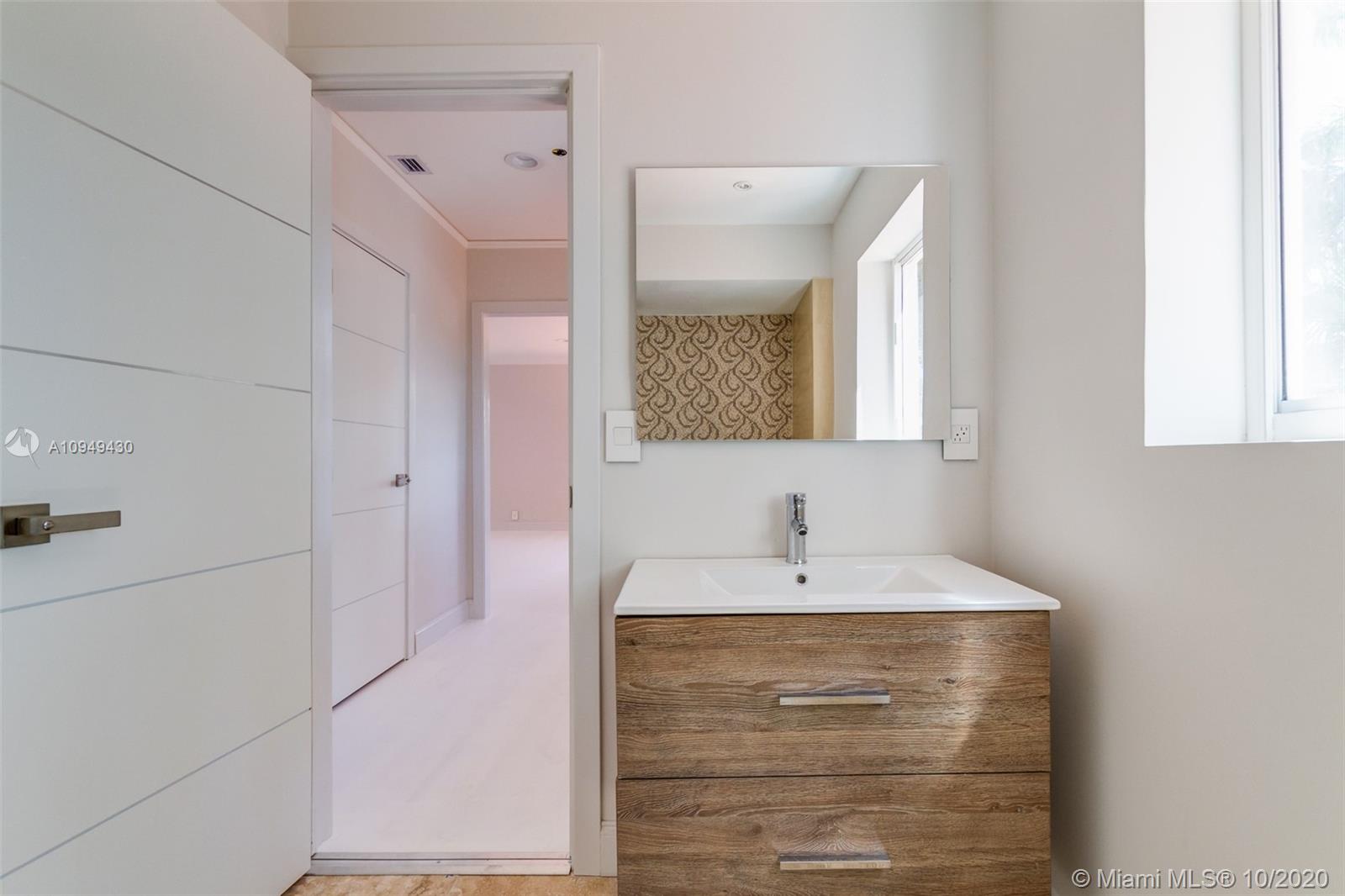 6030 Alton Road Miami Beach, FL 33140 - Photo 33 of 51 a bathroom with a sink and a mirror