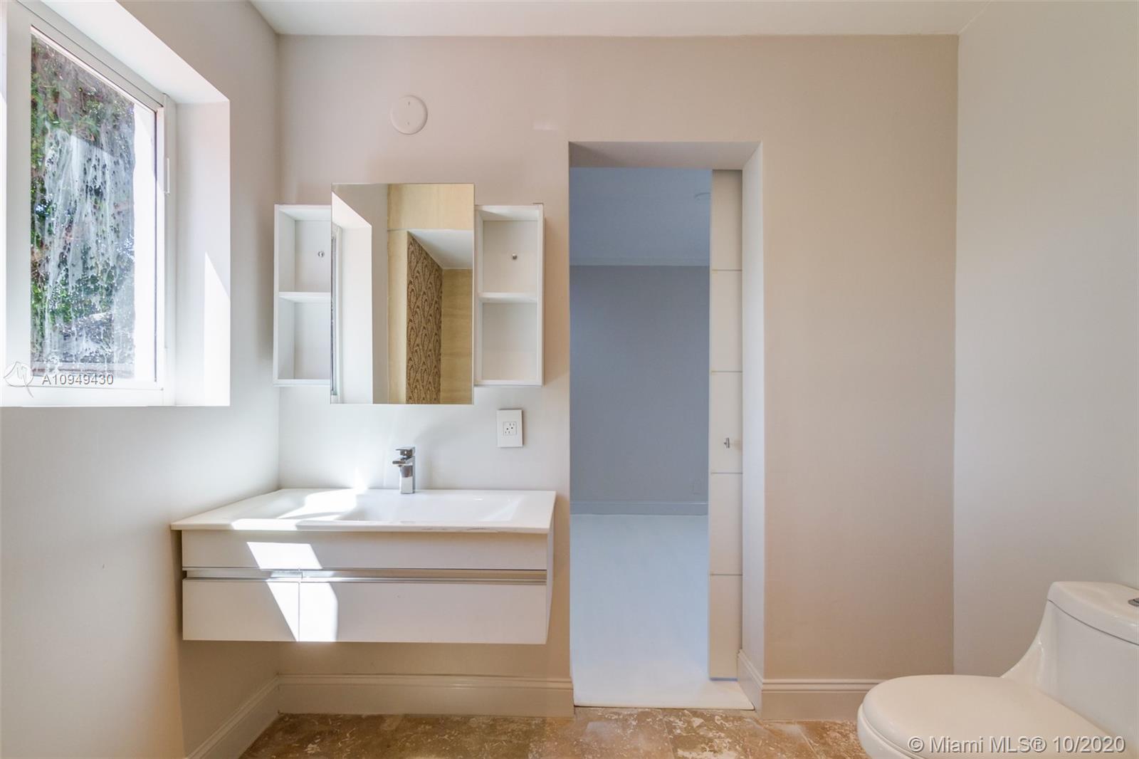 6030 Alton Road Miami Beach, FL 33140 - Photo 38 of 51 a bathroom with a sink and a mirror