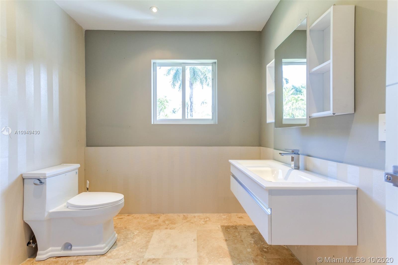 6030 Alton Road Miami Beach, FL 33140 - Photo 45 of 51 a bathroom with a sink a toilet and mirror
