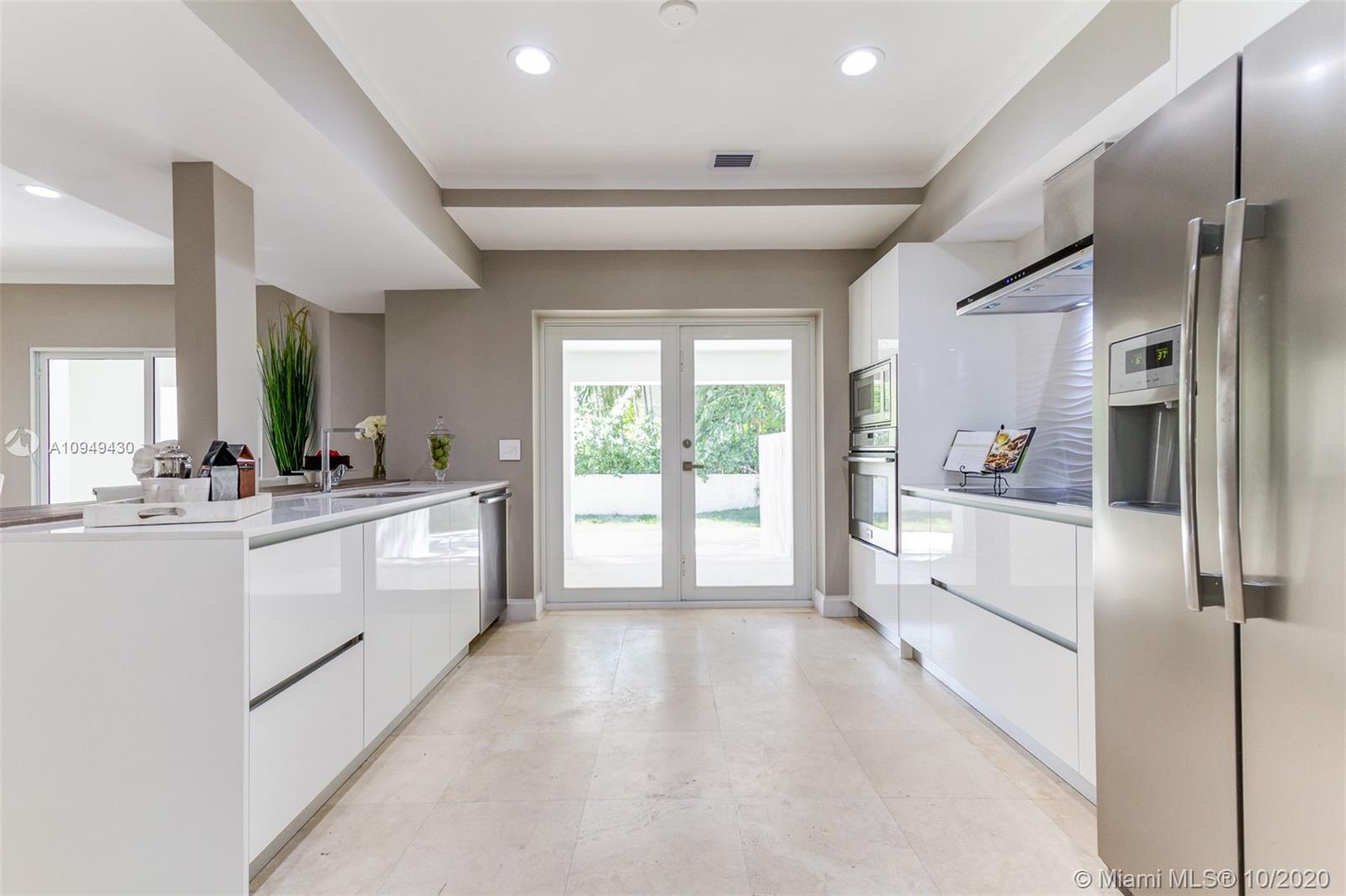 6030 Alton Road Miami Beach, FL 33140 - Photo 9 of 51 a large white kitchen with granite countertop a refrigerator and a sink