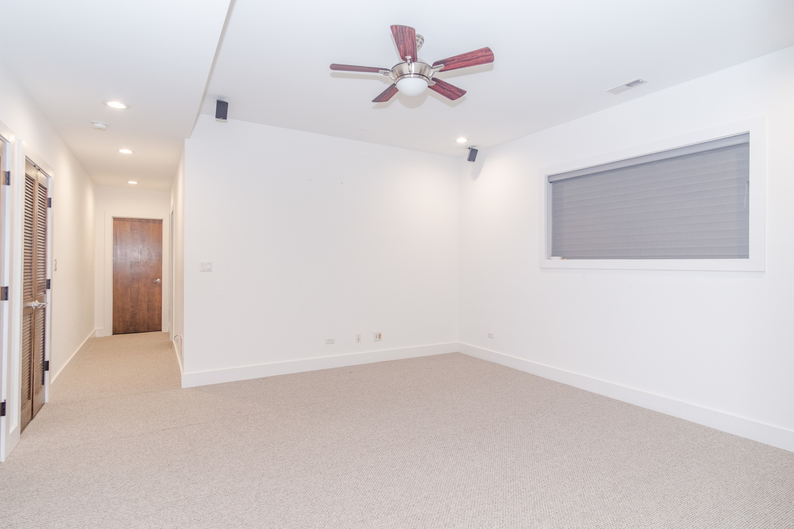1242 West Jackson Boulevard, Unit 1W Chicago, IL 60607 - Photo 17 of 24 an empty room with chandelier fan and windows