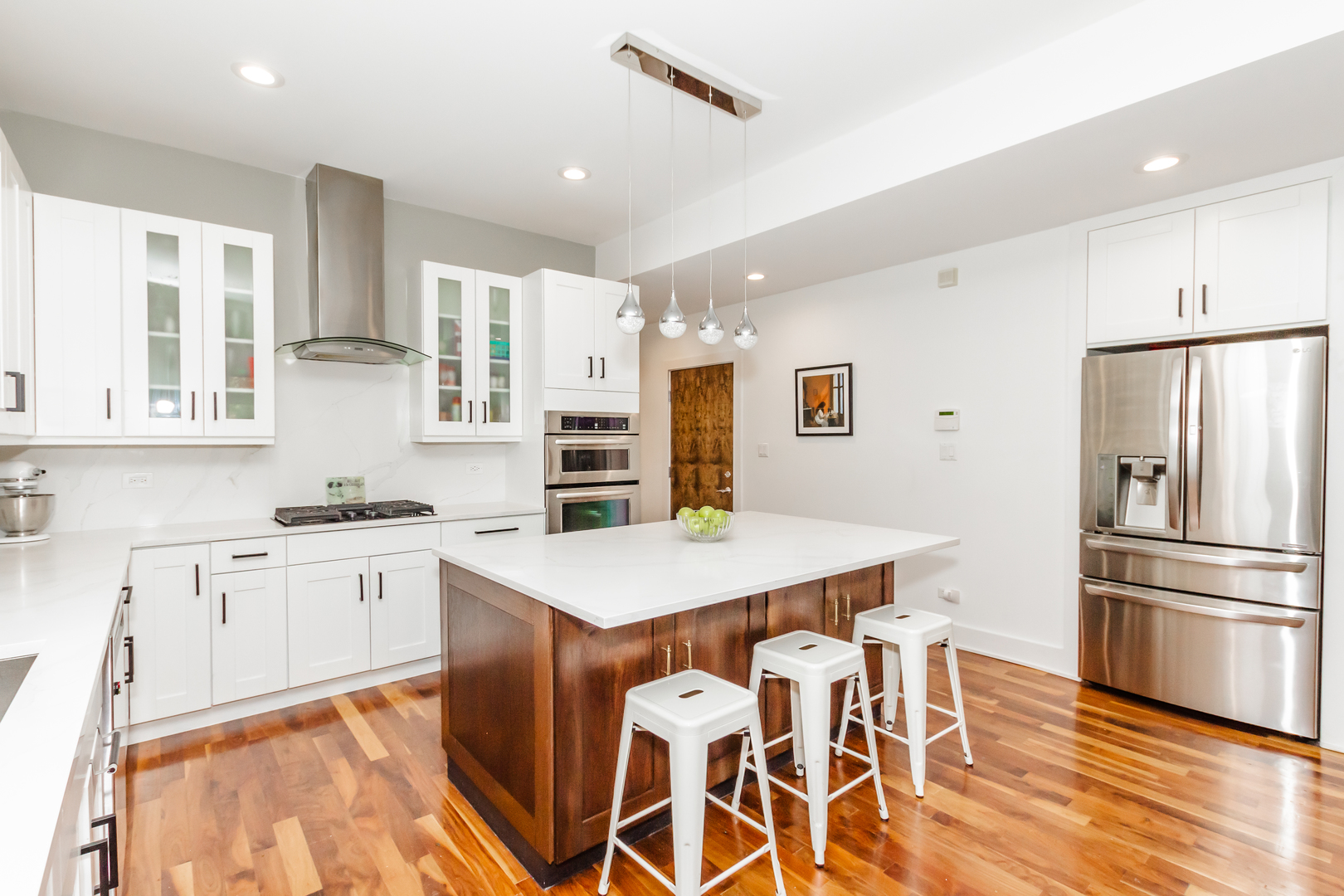 1242 West Jackson Boulevard, Unit 1W Chicago, IL 60607 - Photo 4 of 24 a kitchen with stainless steel appliances kitchen island granite countertop a refrigerator and a stove top oven