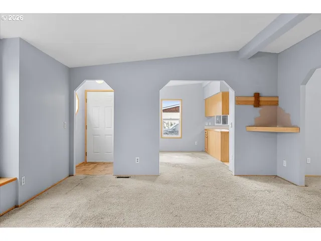 a view of empty room with a kitchen