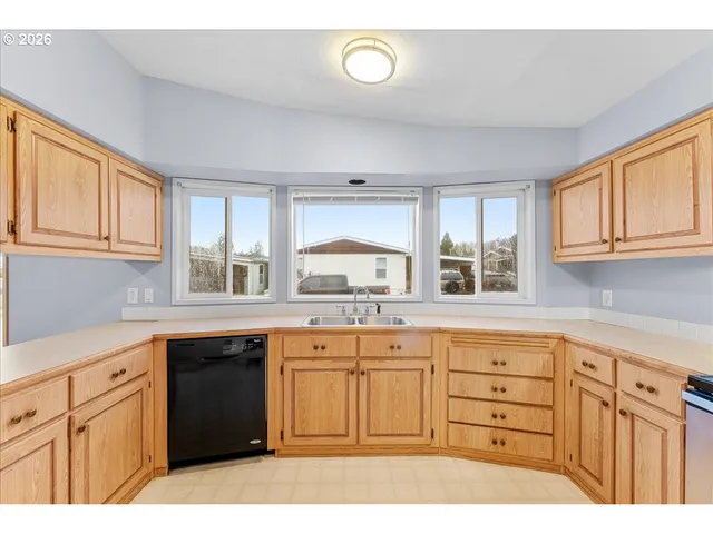a kitchen with cabinets appliances and a window