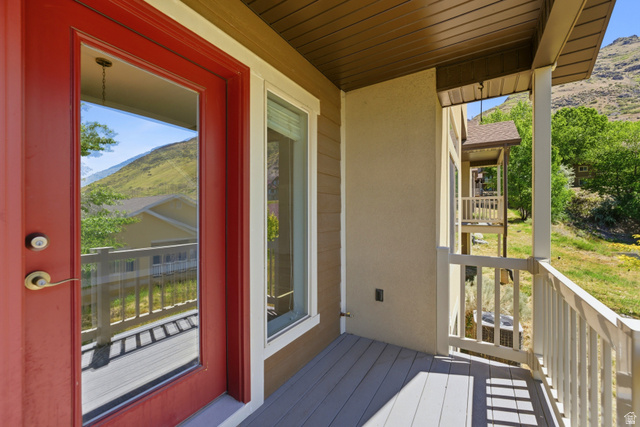 1614 Aspen Loop Provo, UT 84606 - Photo 38 of 47 Exterior porch area featuring a red glass-paneled door, a white-trimmed window, composite decking, and white railing