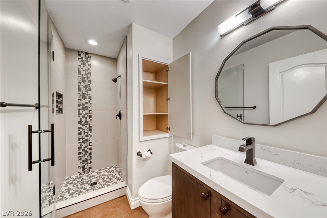 2122 Mooreview Street Henderson, NV 89012 - Photo 29 of 44 A well-appointed bathroom features a glass-enclosed shower with custom tile work and a contemporary vanity with a sleek sink.