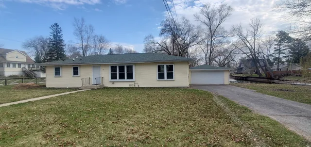 a view of a yard in front of a house with large trees