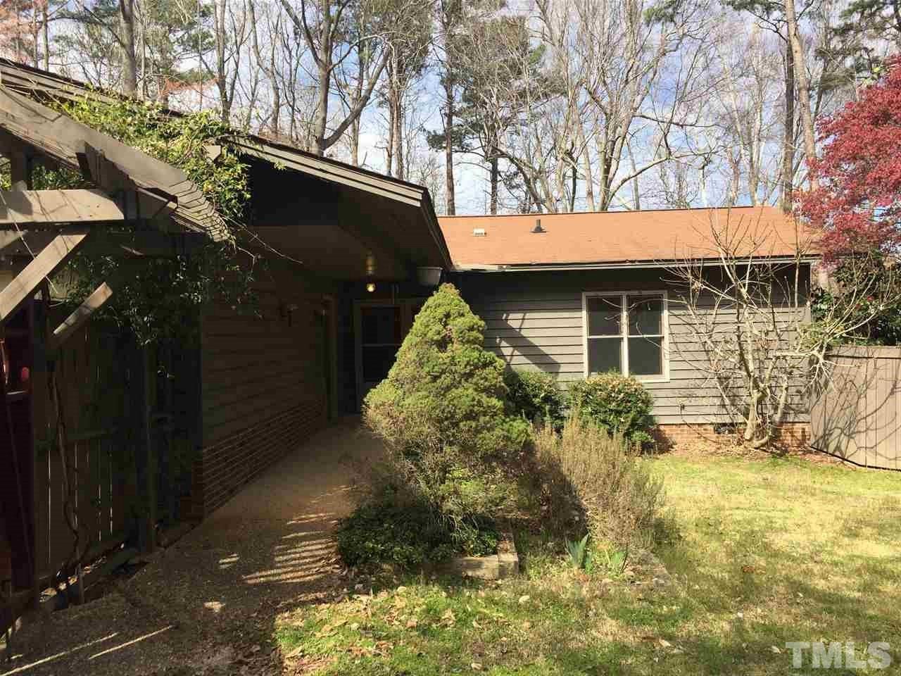 2757 Rue Sans Famille Raleigh, NC 27607 - Photo 5 of 21 a backyard of a house with table and chairs under an umbrella