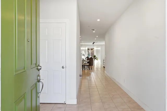 a hallway with a dining table & a mirror