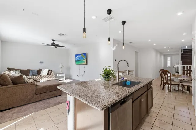 a living room with kitchen island furniture and a chandelier
