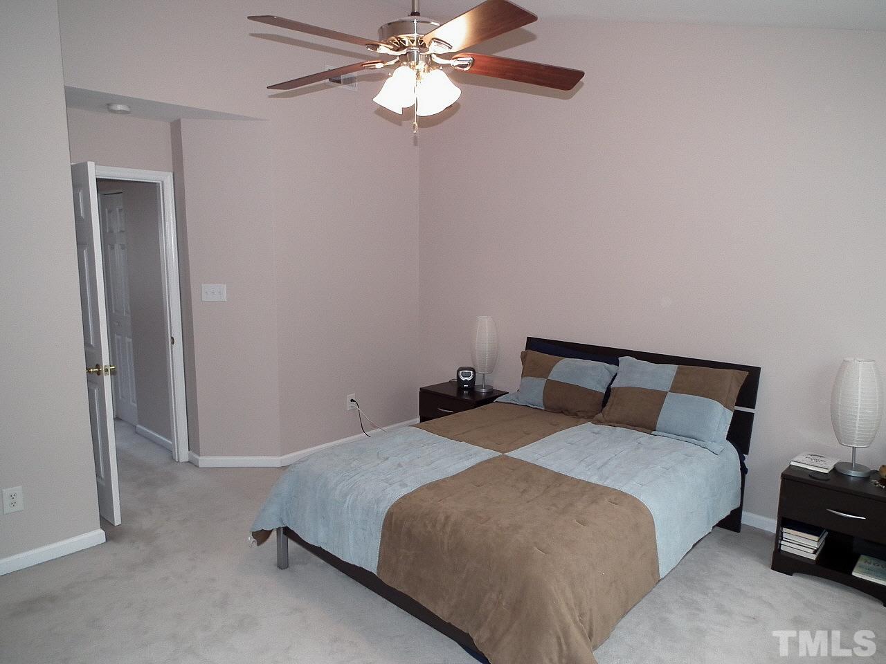 5318 Echo Ridge Road Raleigh, NC 27612 - Photo 18 of 25 a bedroom with a bed and a chandelier