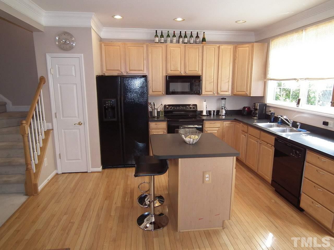 5318 Echo Ridge Road Raleigh, NC 27612 - Photo 3 of 25 a kitchen with a sink a refrigerator a stove a microwave and cabinets