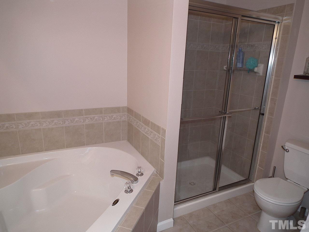 5318 Echo Ridge Road Raleigh, NC 27612 - Photo 21 of 25 a white bath tub sitting next to a toilet