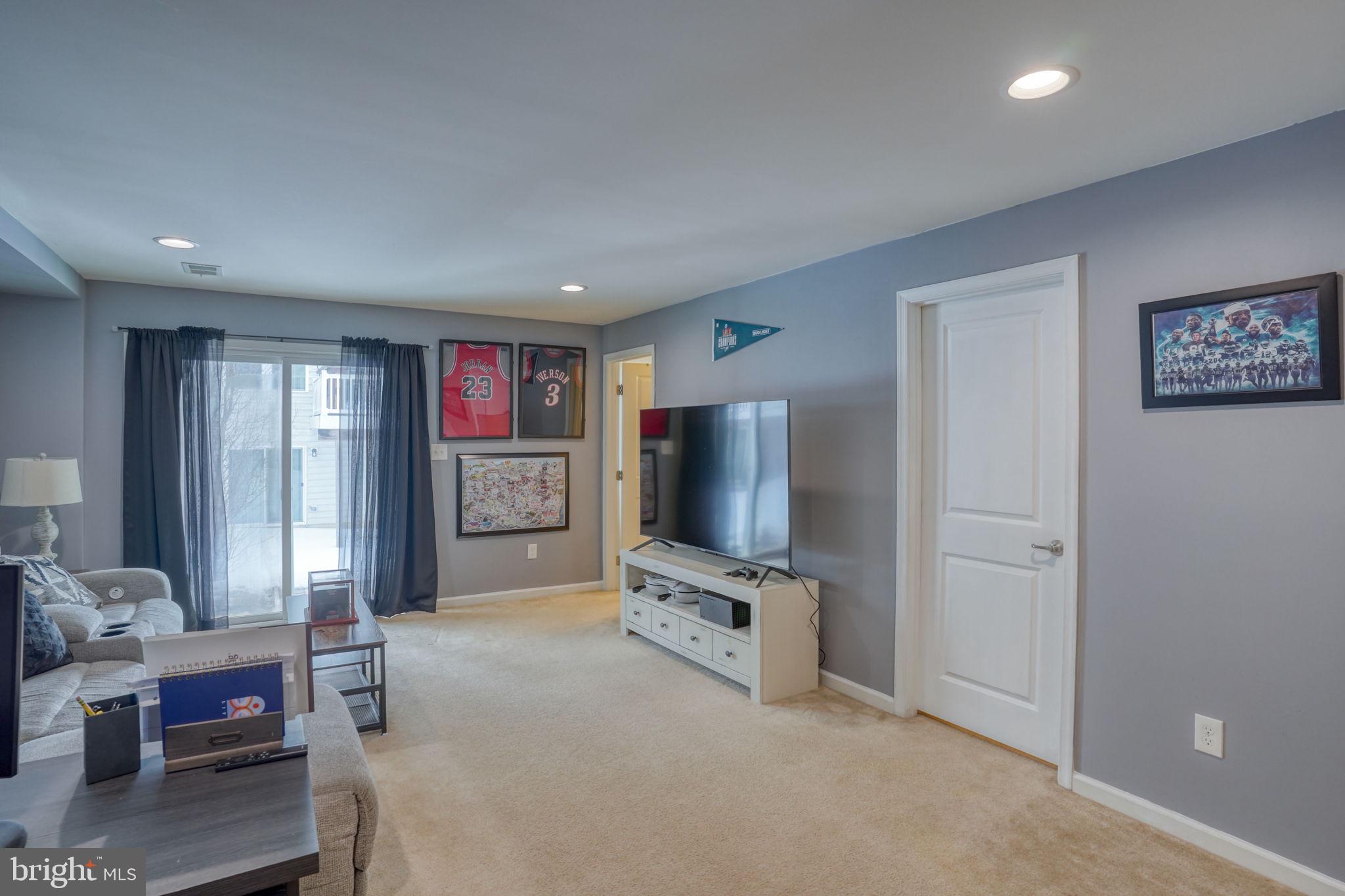 602 Barrie Road Middletown, DE 19709 - Photo 8 of 35 a living room with furniture a flat screen tv and a refrigerator