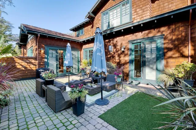 a view of a patio with couches table and chairs and potted plants