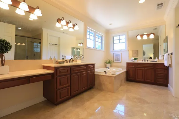 a large bathroom with a large tub sink and mirror