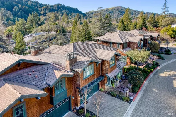 an aerial view of multiple houses with a yard