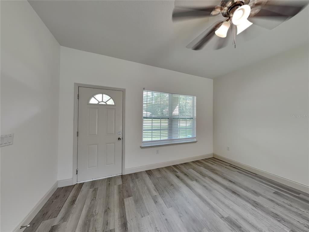 7780 North Maltese Drive Citrus Springs, FL 34433 - Photo 2 of 16 wooden floor in an empty room with a window