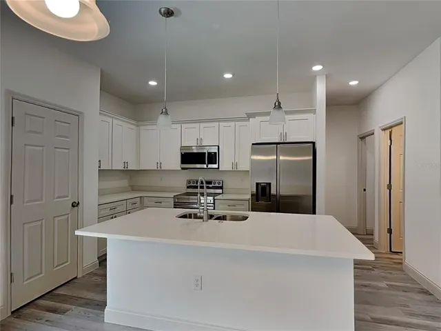 a kitchen with stainless steel appliances a refrigerator sink and microwave