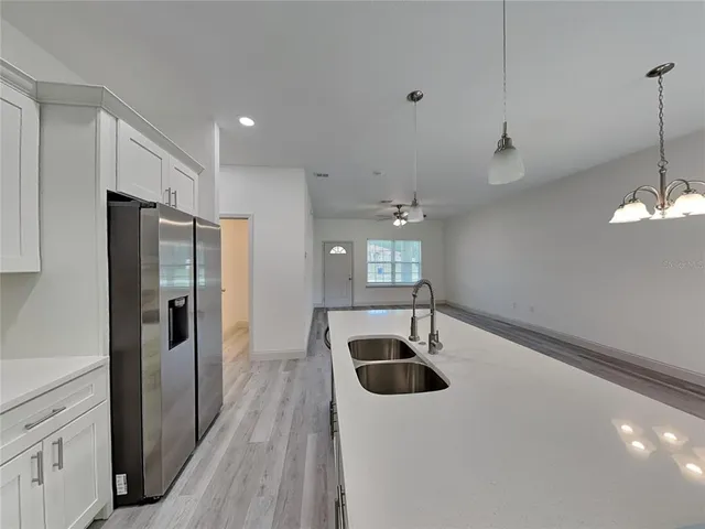 a kitchen with stainless steel appliances a sink a refrigerator a counter space and cabinets