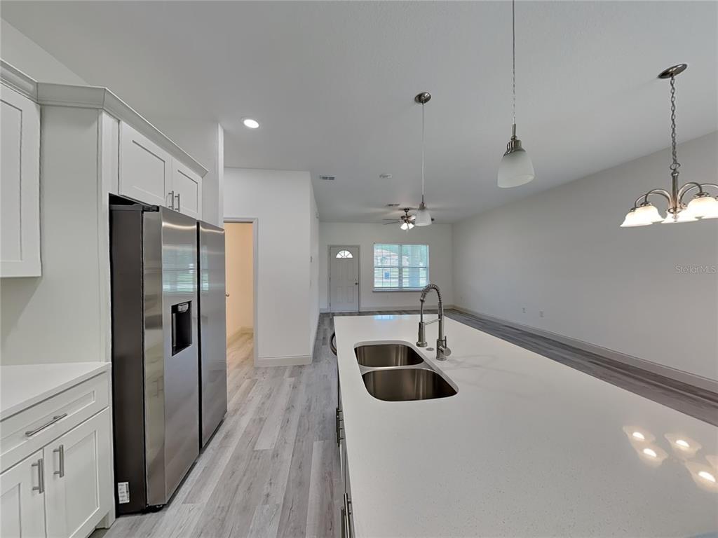 7780 North Maltese Drive Citrus Springs, FL 34433 - Photo 5 of 16 a kitchen with stainless steel appliances a sink a refrigerator a counter space and cabinets