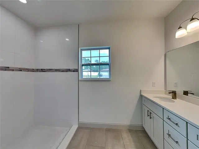 a bathroom with a sink mirror and a shower