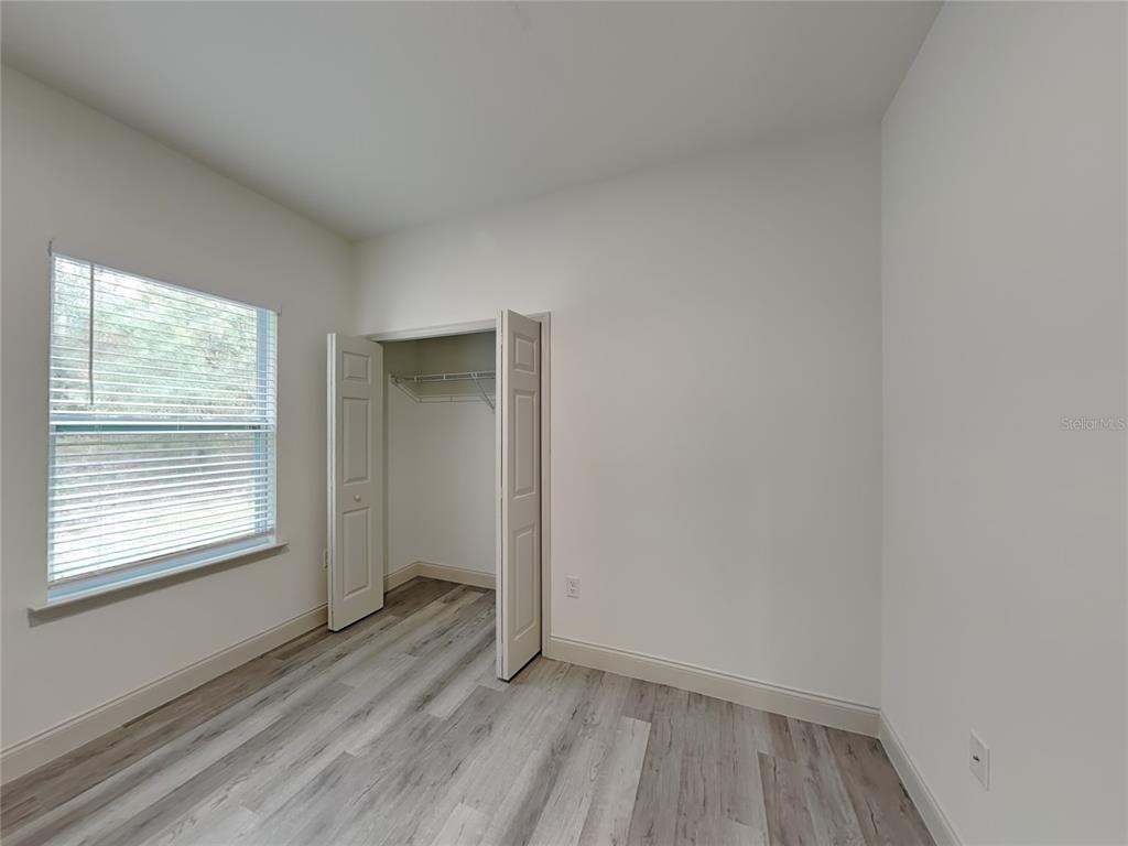 7780 North Maltese Drive Citrus Springs, FL 34433 - Photo 10 of 16 an empty room with wooden floor and windows