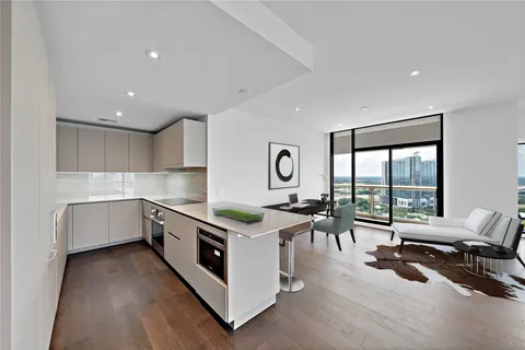 a kitchen with stainless steel appliances white cabinets and wooden floor
