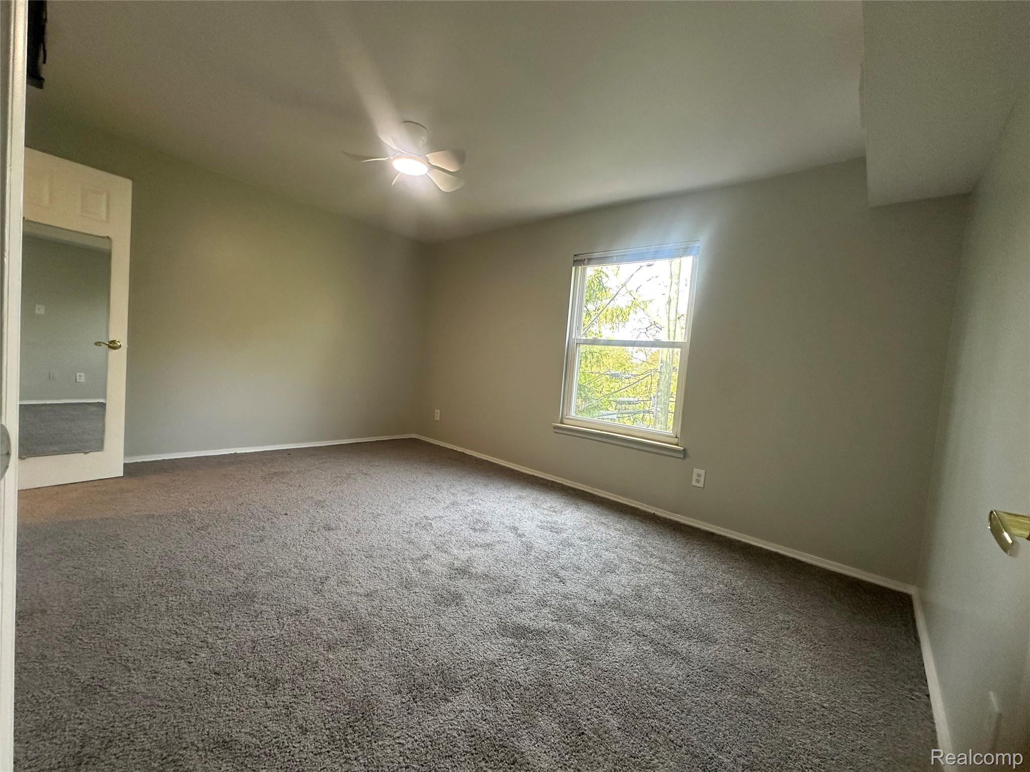 509 East University Drive Rochester, MI 48307 - Photo 9 of 20 Empty room featuring carpet flooring and ceiling fan