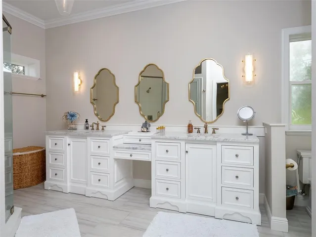 a bathroom with double vanity white cabinets and a mirror