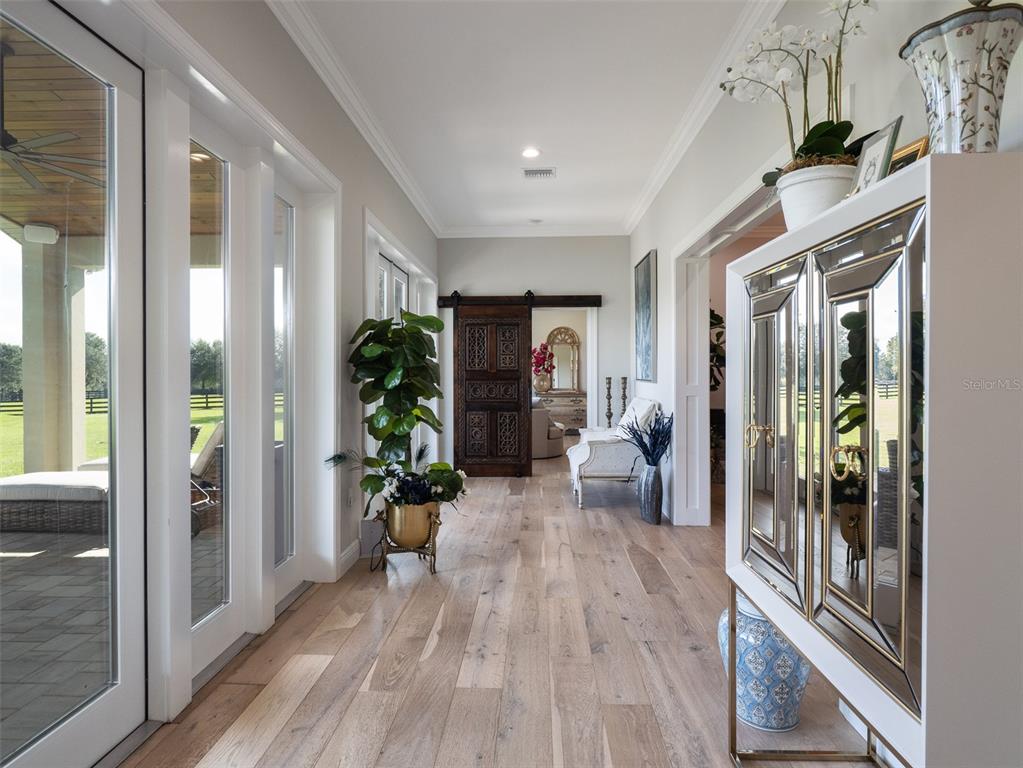15225 Northwest 112th Place Road Morriston, FL 32668 - Photo 16 of 39 a hallway with wooden floor and a couch