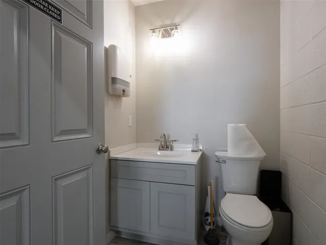 a bathroom with a toilet a sink and mirror