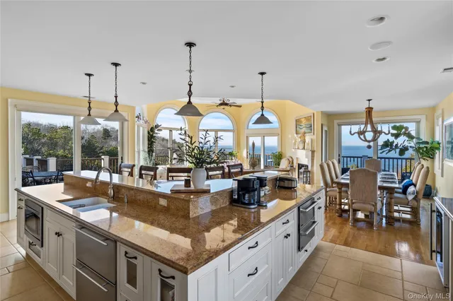 a kitchen with stainless steel appliances granite countertop a stove and a view of living room