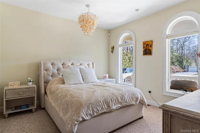 a bedroom with a large bed and windows