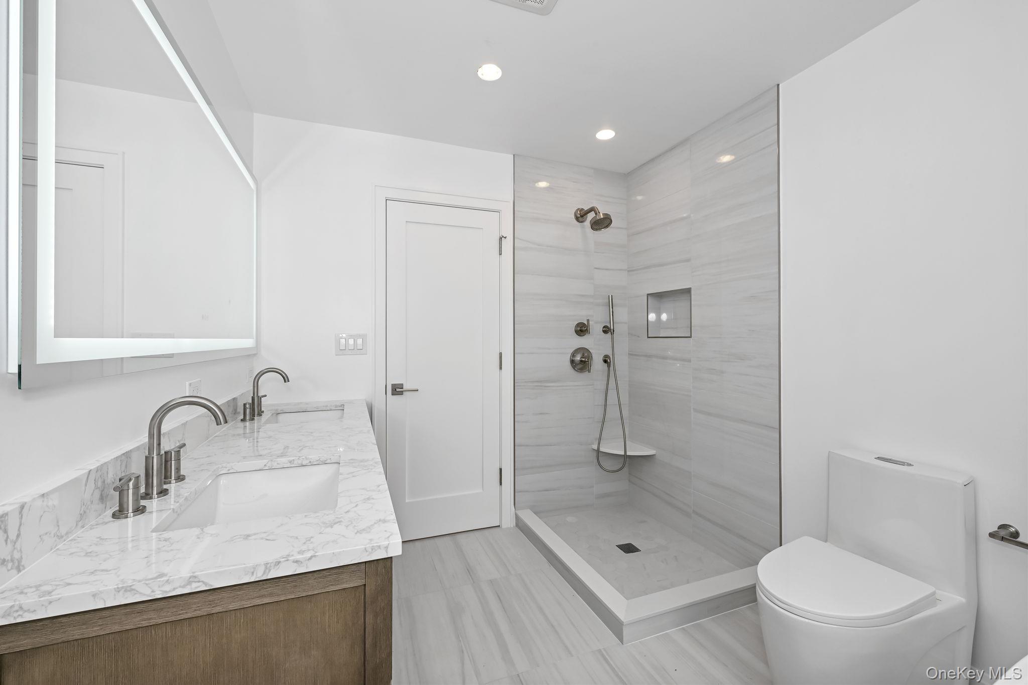 24 Country Road Mamaroneck, NY 10543 - Photo 19 of 37 a bathroom with a shower sink vanity mirror and toilet